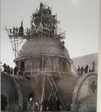 The basilica of Saint George going up. The whole village is on the scaffolding — on the domes, on the vaults, on ladders — to see the work finished.